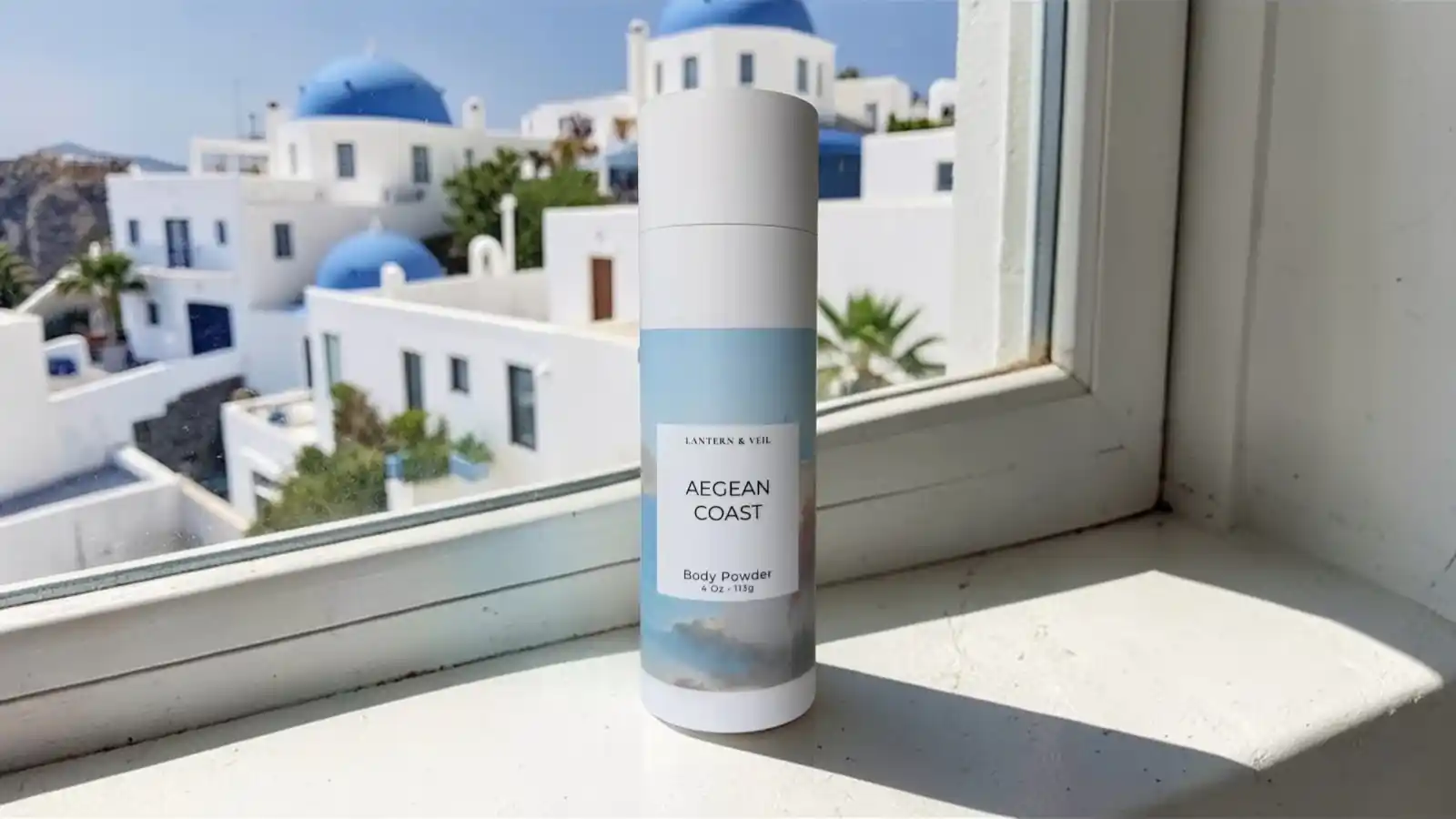 Lantern & Veil Aegean Coast body powder with Mediterranean coastal backdrop