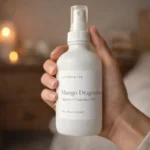 Woman holding Lantern & Veil Mango Dragonfruit signature fragrance mist spray bottle